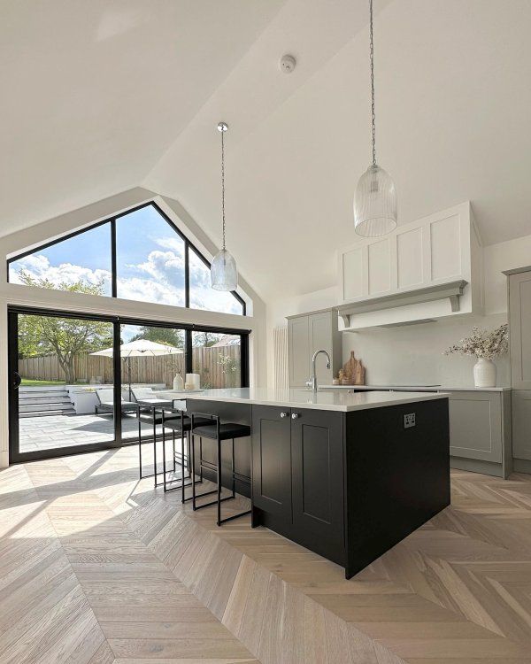 an open kitchen and dining area with large windows