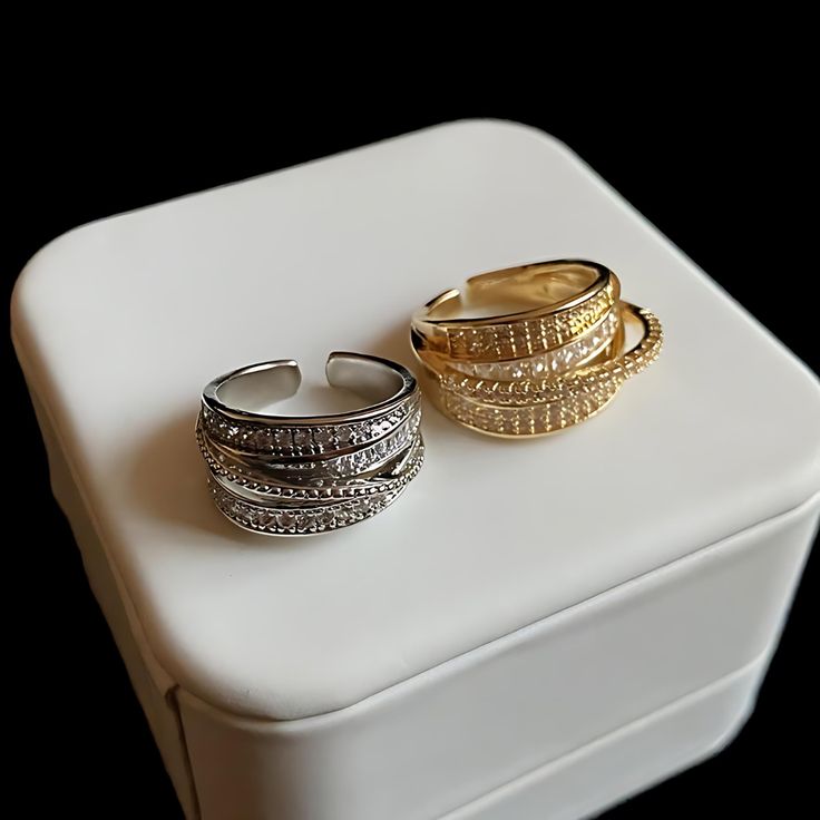 ✦ Indulge in the elegant allure of our Dainty Multi-Layer CZ Ring. This exquisite cocktail ring features multiple layers of sparkling CZ (Cubic Zirconia) stones, creating a captivating and glamorous look. Available in both gold and silver finishes, this ring offers versatility to suit your personal style. Its dainty design adds a touch of sophistication, making it perfect for special occasions or adding a touch of glamour to your everyday attire. Elevate your jewelry collection with our Dainty M Wide Ring, Wide Rings, Cz Ring, Cocktail Ring, Cocktail Rings, Gold And Silver, Multi Layering, Statement Pieces, Cubic Zirconia