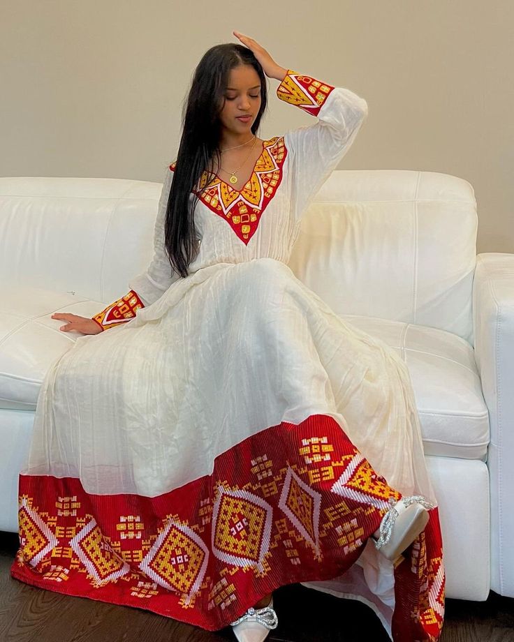 This Habesha Kemis, a traditional Ethiopian garment, radiates beauty and elegance, reflecting the rich cultural heritage and craftsmanship of Ethiopia. This exquisite dress showcases a perfect harmony of handwoven fabric, intricate embroidery, the use of Menen fabric, lightweight cotton, and quality thread, creating a stunning ensemble that captivates the eye and the heart. At the core of the Habesha Kemis lies the handwoven fabric, a testament to the skill and dedication of Ethiopian weavers. U Eritrean Dress, Ethiopian Clothing, Habesha Dress, Ethiopian Traditional Dress, Ethiopian Women, Ethiopian Dress, Ethiopian Music, Habesha Kemis, Handwoven Fabric