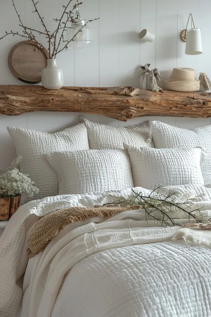 a bed with white linens and pillows in a bedroom next to a wooden headboard