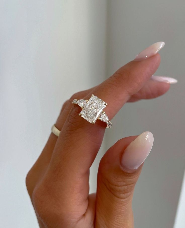 a woman's hand with a ring on it and a diamond in the middle