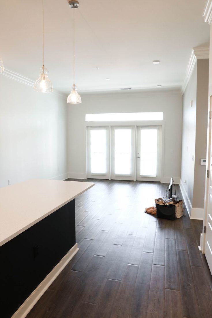 an empty room with hard wood flooring and white walls is seen in this image