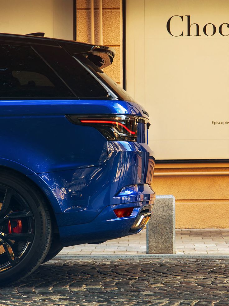 a blue car parked in front of a building