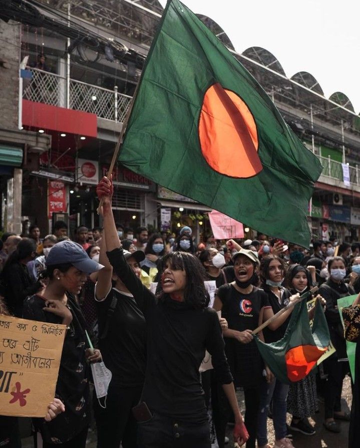 a large group of people holding flags and signs in the middle of a city street