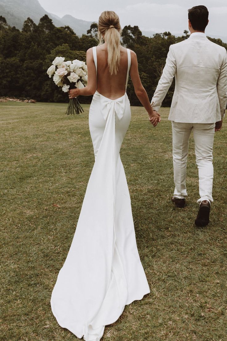 a bride and groom walking hand in hand