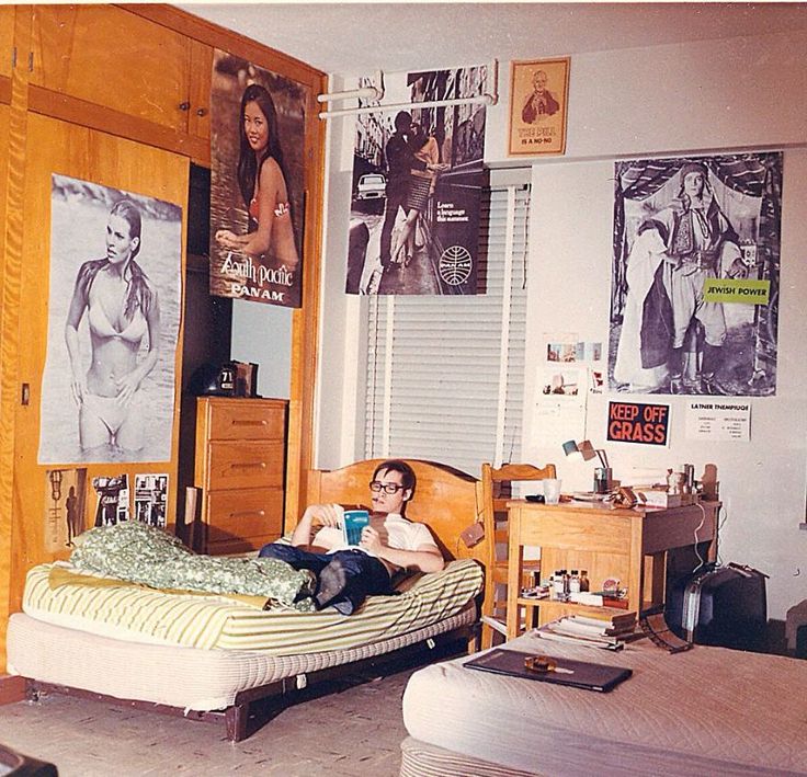 a man laying on top of a bed in a bedroom next to two dressers