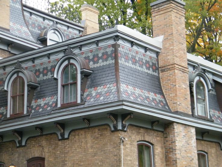 an old brick house with decorative tile on the roof