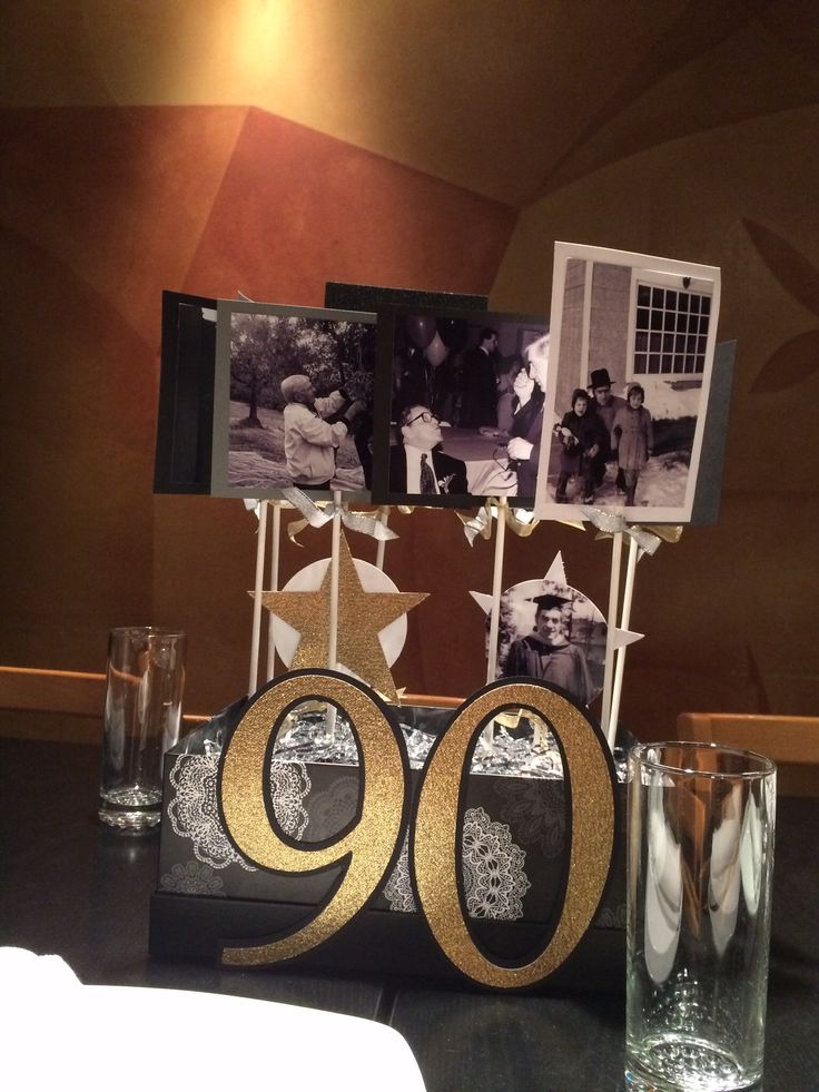 the table is set up with photos, candles and other things to celebrate someone's 90th birthday