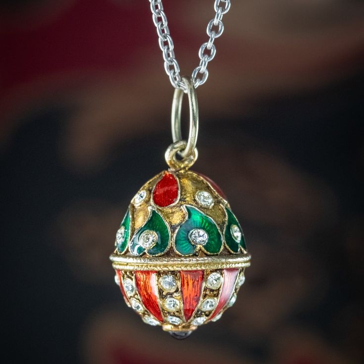 "This fabulous vintage egg pendant is beautifully decorated with twinkling white pastes, a cabochon garnet on the bottom and teardrop and leaf motifs, highlighted in bright red and green guilloche enamel.  Guilloche enamel dates to the 17th century and involves metal carefully worked by a lathe, or \"Rose Machine\" into a decorative pattern and overlaid with a colourful enamel to create a striking and highly detailed work of art.  It's a beautiful design, similar to that of a Faberge egg and is modelled in gold metal and is accompanied by a sterling silver cable chain to display it on.  WEIGHT: Egg 9.7 grams - Chain 3.6 grams   MEASURES: Egg Height 20mm (30mm inc. loop) x Width 16mm x Depth 16mm - Chain Length 18 inches x Width 1.5mm  METAL: Base Metal/ Sterling Silver chain STONES: Glass Vintage Enamel Oval Pendant Jewelry, Vintage Enamel Oval Pendant Necklace, Ornate Red Teardrop Jewelry, Multicolor Teardrop Enamel Jewelry, Formal Enamel Oval Pendant Jewelry, Multicolor Enamel Teardrop Jewelry, Collectible Enamel Jewelry With Oval Pendant, Collectible Enamel Oval Pendant Jewelry, Ornate Multicolor Necklace For Gift