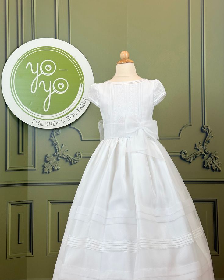 Alma is a coquette first communion dress made with optic white organza, it has super dainty lace on the chest and sleeves. The bow is sown to the dress; however, it can be unstitch. Some dresses may have a slightly different lace on the chest and sleeves. Made in Spain Does not include crinoline Dry Clean 100% polyester Final sale, no exchanges nor returns will be accepted after purchase Fitted Dress With Bow For Confirmation, Elegant Bow Dress For Confirmation, Elegant Confirmation Dress With Bow, Organza Baptism Dress With Bow, Fitted White Baptism Dress With Satin Bow, White Fitted Baptism Dress With Satin Bow, Fitted Bow Dress For First Communion, Elegant First Communion Dress With Fitted Bodice, Elegant First Communion Dress With Short Sleeves