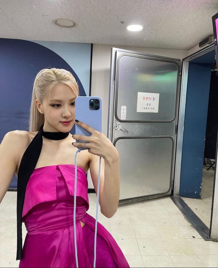 a woman in a pink dress taking a selfie