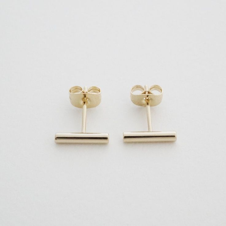 Rounded bar earrings with a center back stud. Wear 'em alone or alongside your favorite studs. Measures 1.5 x 11 mm. Our materials make for an amazing, high quality, seamless, jewelry piece with longevity. Our earrings are plated with 18k gold, 18k rose gold, or rhodium and are finished with a protective coating. A little secret we'll keep between us: it looks way more than it costs. Delicate Gold Jewelry, Gold Bar Earrings, Ear Climbers Earrings, Jewellery Marketing, Bar Stud Earrings, Bar Studs, Round Bar, Between Us, Delicate Jewelry