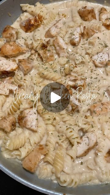 a pan filled with pasta and chicken on top of a stove