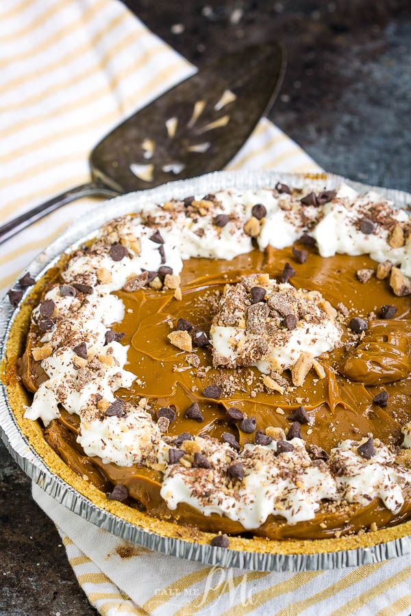 a pie with chocolate and marshmallows on top is sitting on a table