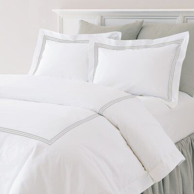 a bed with white sheets and blue trimmings is shown in this image from the front