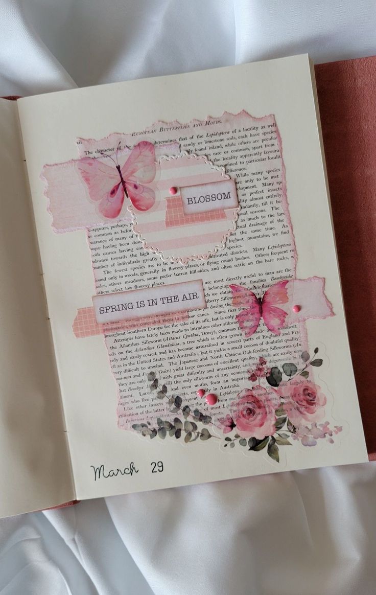 an open book with pink flowers and butterflies on it