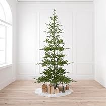 a small christmas tree in the corner of a room with white walls and wooden floors