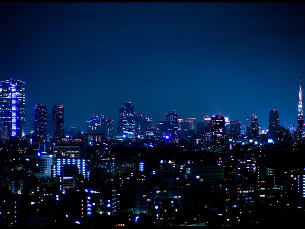 the city skyline is lit up at night with bright lights in the buildings and skyscrapers