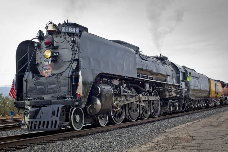 an old fashioned train is traveling down the tracks