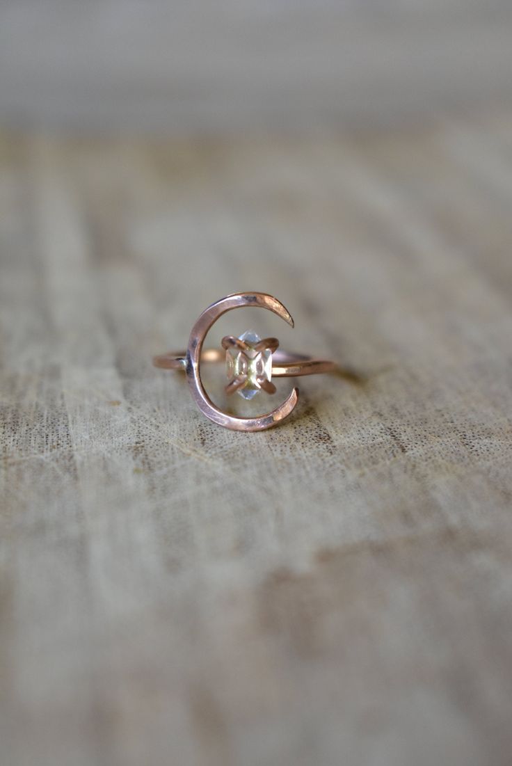 Rose Gold Moon Ring & Flawless Herkimer Diamond. Crescent moon and clear quartz crystal ring. This piece is a stunning rose gold fill with lightly hammered half moon. A lunar, celestial ring with a bright, clear Herkimer Diamond, a form of quartz crystal! The design is adjustable and cut from your size, so it also fits up to 10.0 if you like to wear rings on different fingers. The Herkimer crystal floats inside the crescent, but can move outside of it too. It's unique, feminine and sophistic Celestial Rose Gold Round Crystal Ring, Celestial Rose Gold Crystal Ring, Celestial Rose Gold Crystal Promise Ring, Rose Gold Moon Charm Jewelry For Wedding, Rose Gold Moon Charm Wedding Jewelry, Rose Gold Jewelry With Moon Charm For Wedding, Celestial Style Rose Gold Ring, Celestial Rose Gold Jewelry With Rose Cut Diamonds, Rose Gold Round Mystical Jewelry