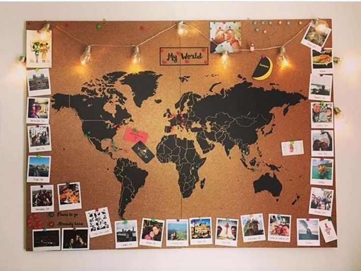 a cork board with pictures on it and lights strung from the top to the bottom