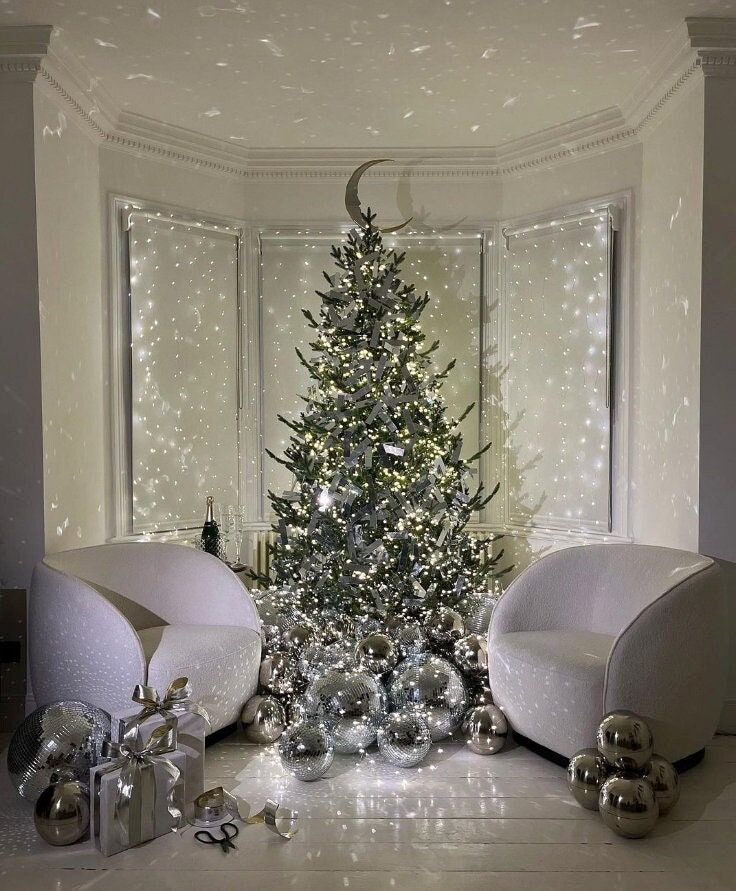 a white christmas tree with silver balls and ornaments