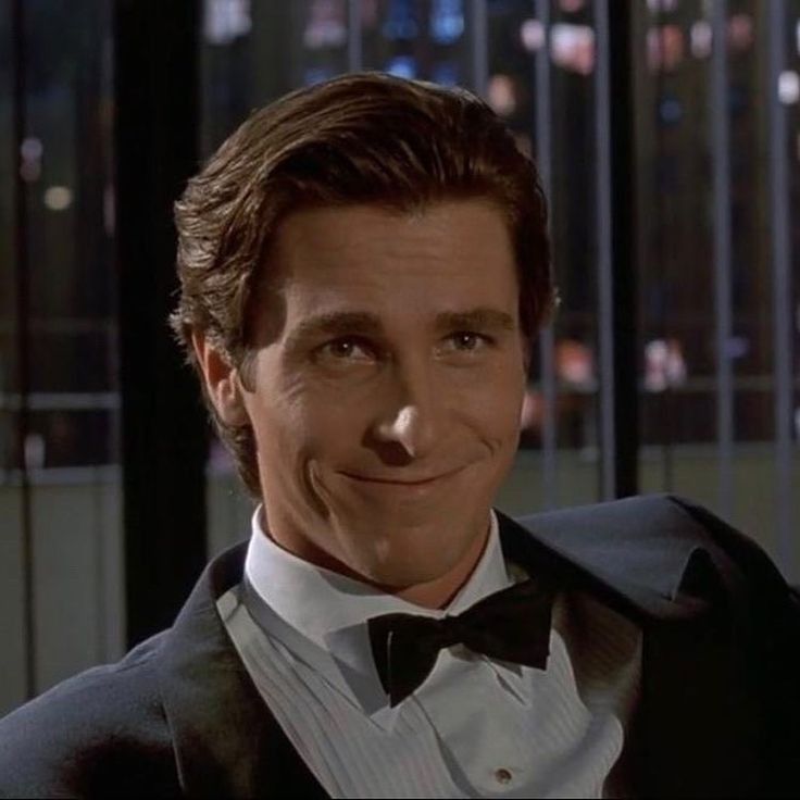 a man in a tuxedo smiles at the camera