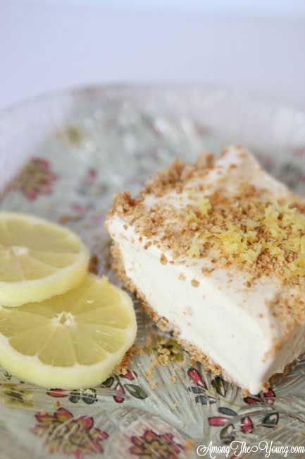 a piece of cake on a plate with lemons and cinnamon sprinkles