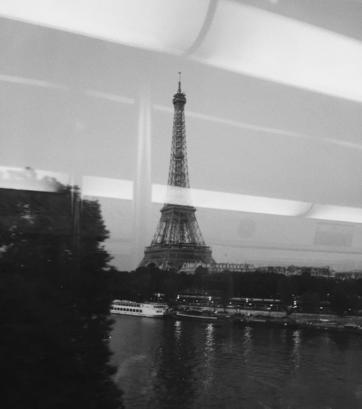 the eiffel tower is seen from across the river in black and white photo