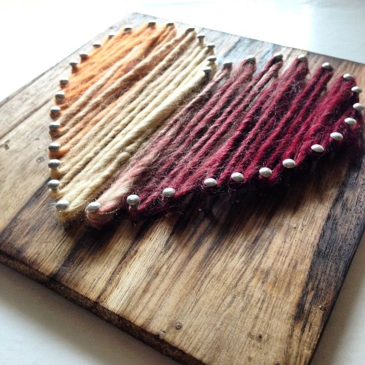 three different colored straws are on a wooden cutting board and one is made out of wood