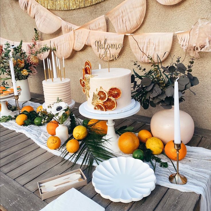 a table topped with a white cake and oranges