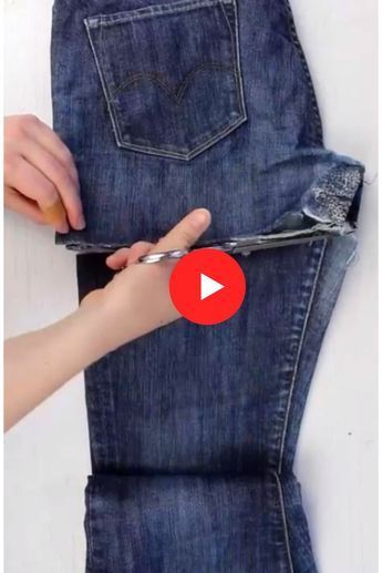 someone is using scissors to cut the back of their jean pants and tie them together