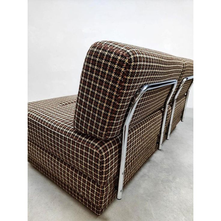 a brown and white checkered couch sitting on top of a floor