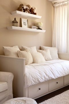 a white day bed sitting in a bedroom next to a window