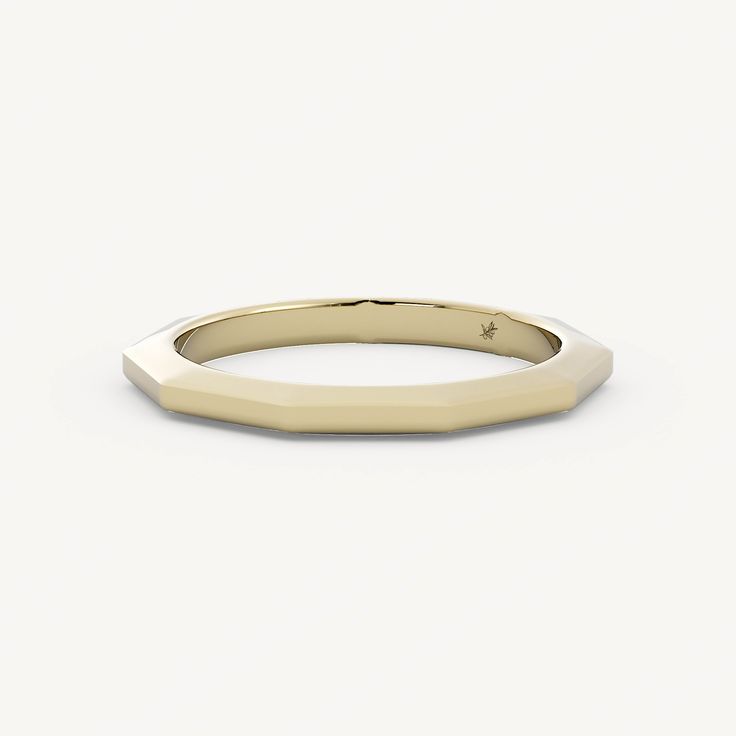 a gold wedding ring with a thin band on the top and an irregular shaped edge