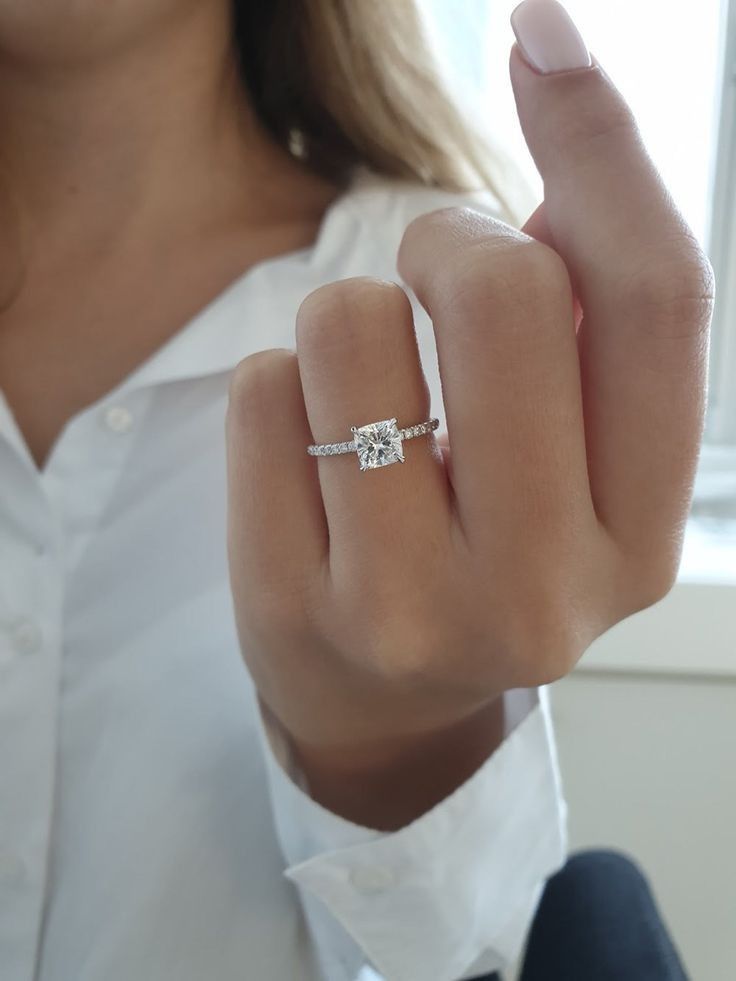 a woman wearing a white shirt and diamond ring