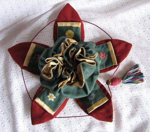 a red and green star with tassels laying on top of it's side