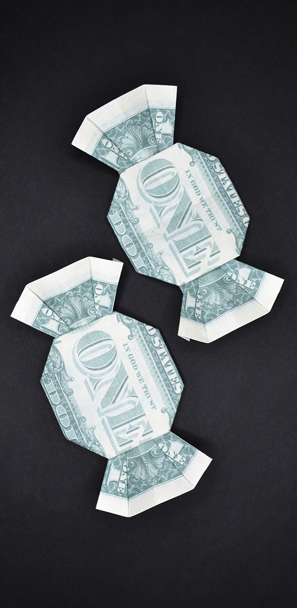 three origami dollar bills are folded up on a black surface