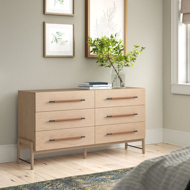 a bedroom with a dresser and pictures on the wall