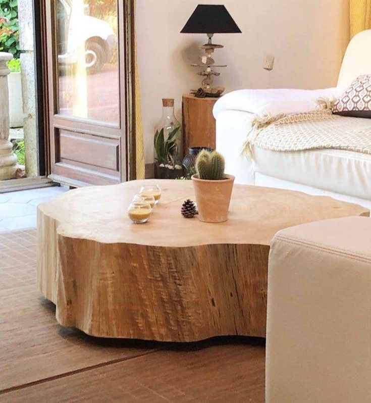 a living room filled with furniture and a wooden table topped with a potted plant