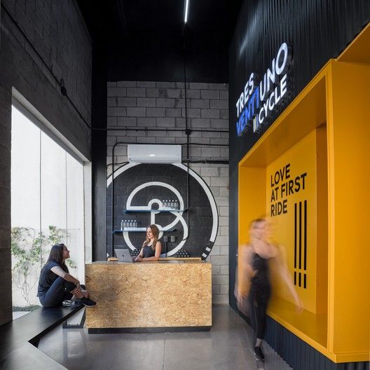 two people sitting in front of a yellow and black reception desk