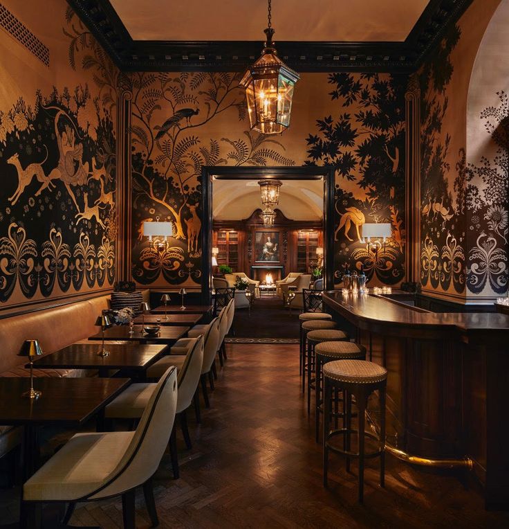 an ornately decorated restaurant with bar stools and wooden tables in front of it