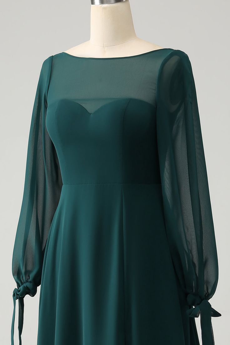 a green dress on a mannequin dummy with long sleeves and tie around the waist