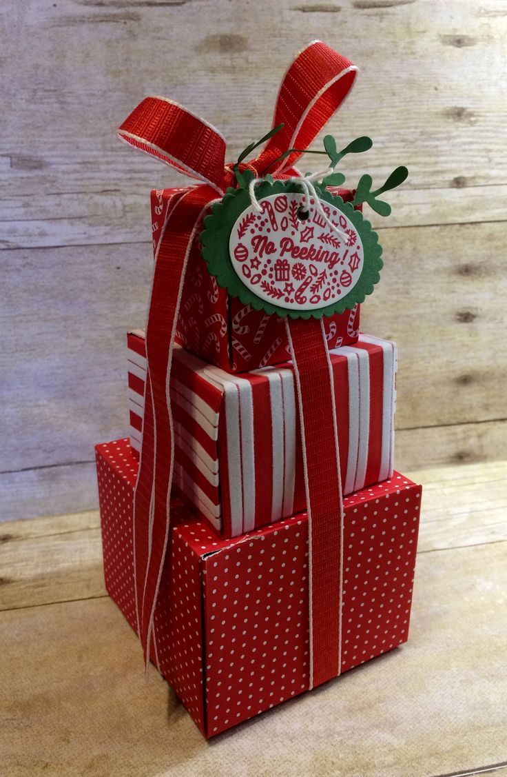 three red and white wrapped presents stacked on top of each other