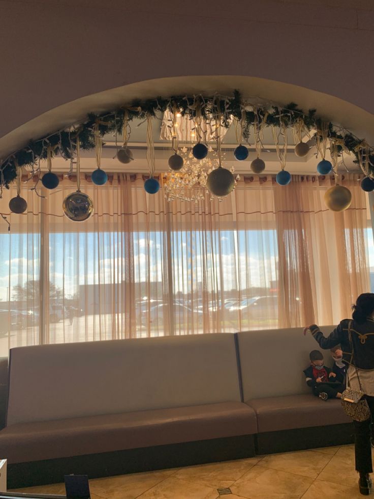 a living room filled with furniture and lots of hanging ornaments on the windows sill