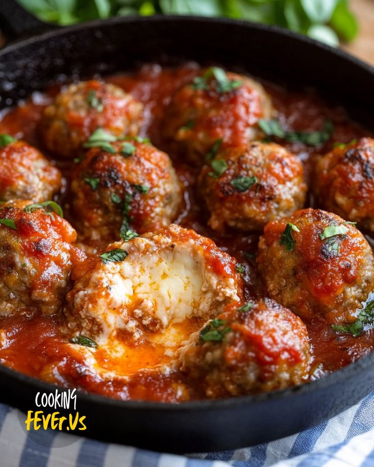 some meatballs are in a pan with sauce and parsley on the side, ready to be eaten