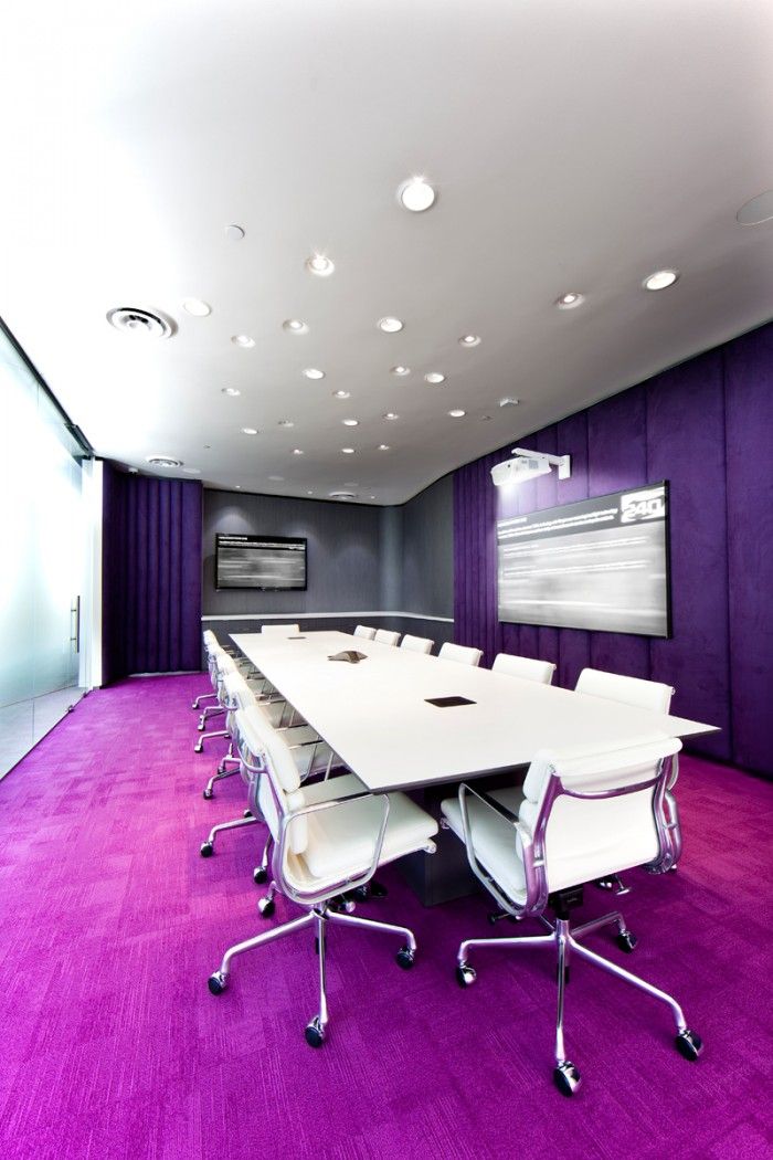 a conference room with purple carpet and white chairs