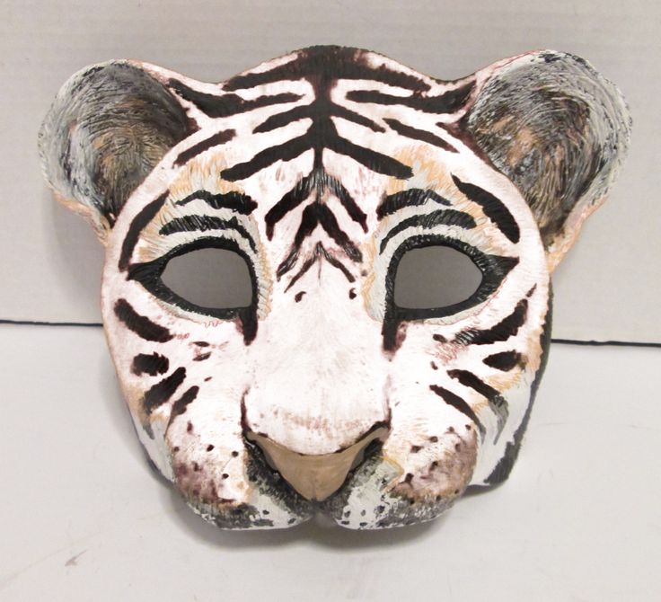 a white tiger mask with black stripes on it's face is shown in front of a wall