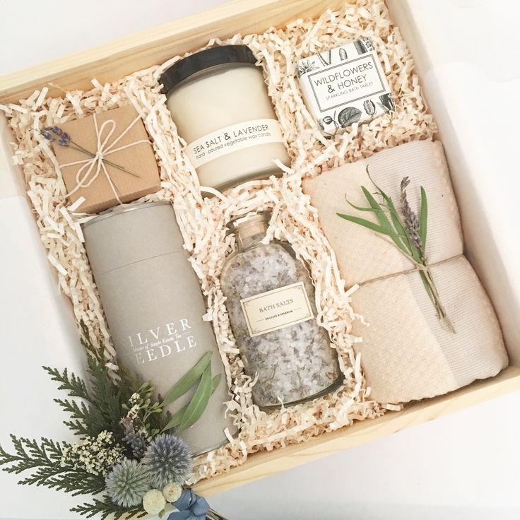 an open gift box containing candles, soaps and other personal care items in it