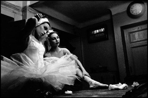 two ballerinas are sitting on the floor in their tutus